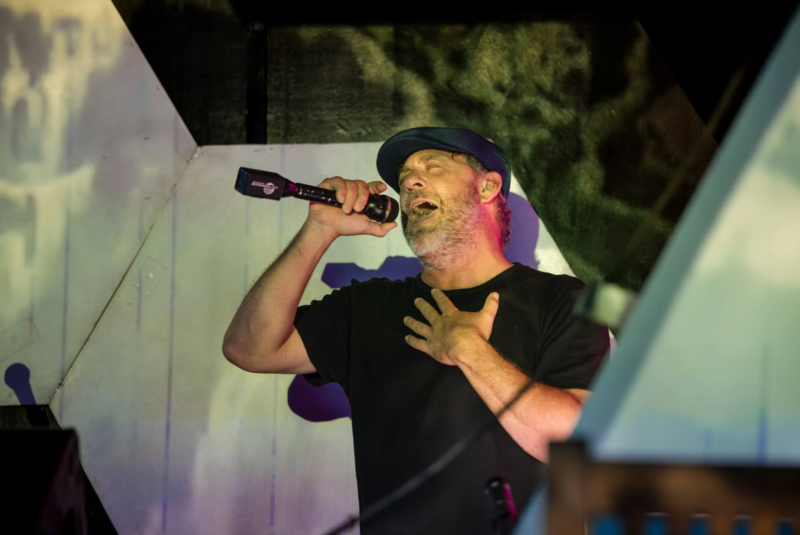 Photo of Chris Berry on the mic in Hawaii at a prayerformance fusing live vocals, percussion and dance with electronic beats. Photo by Lali Photo Creative