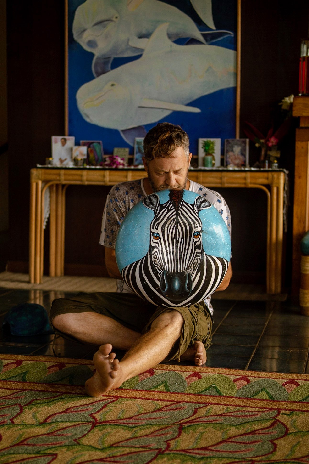 Photo of Chris Berry playing mbira in a Zebra-painted deze (resonator). Photo by Bailee Aubrey